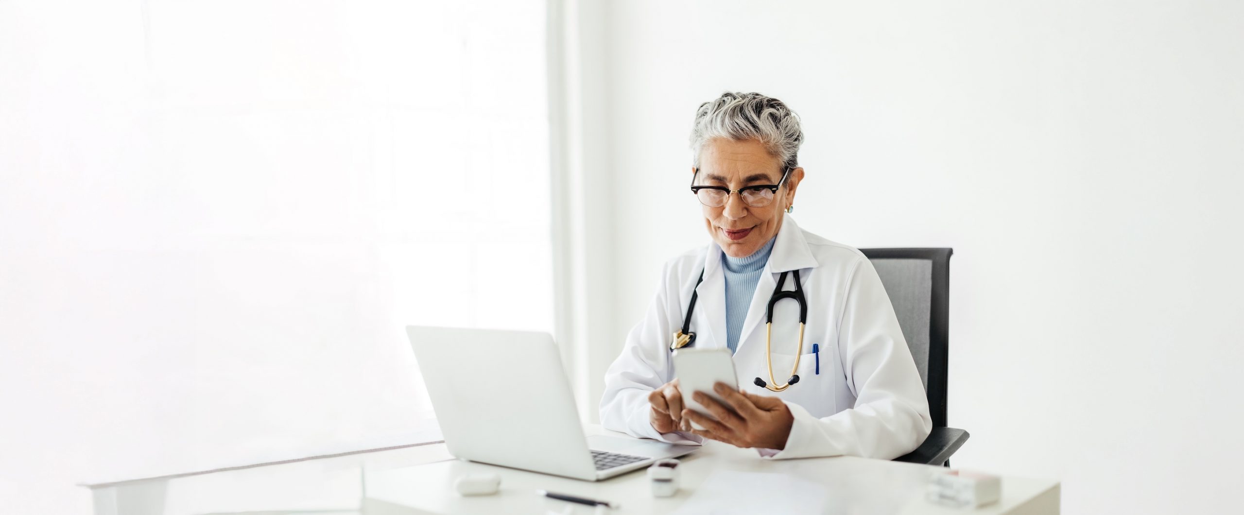 Médecin utilisant un smartphone dans son bureau